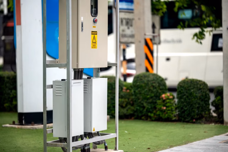 An electric public bus charges at a station in a modern city