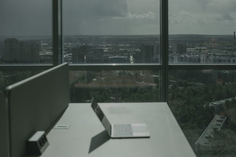 Laptop at a desk overlooking a city skyline