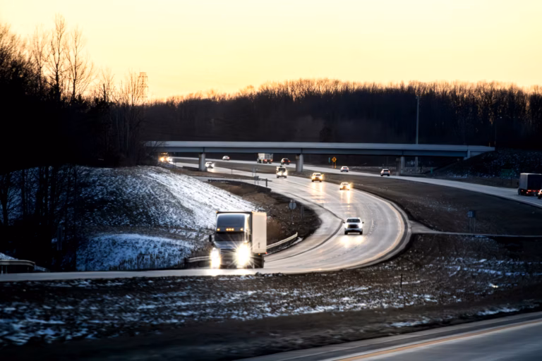 Autonomous semi-truck driving on a multi-lane highway during dusk