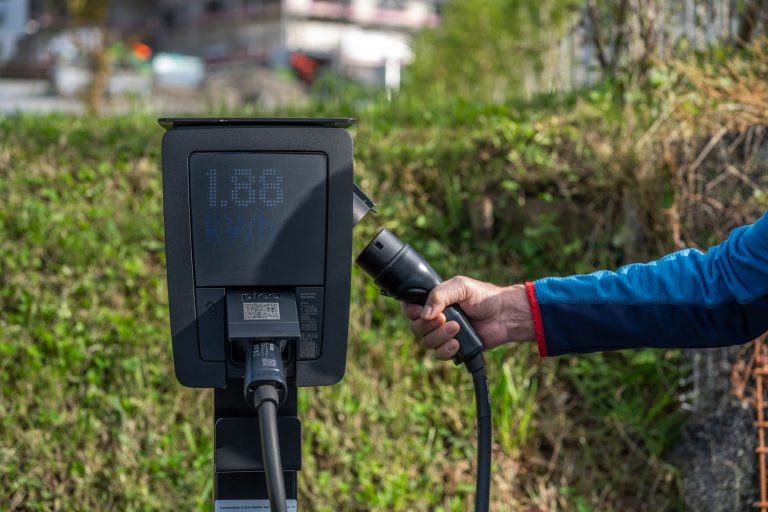 A large EV charging hub with multiple stalls and a visible battery storage unit