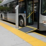 Accessible bus stop with low-floor bus, extended ramp and bright tactile paving for safe level boarding