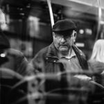 Passengers seated inside a bus in a black-and-white public-transit scene