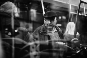 Passengers seated inside a bus in a black-and-white public-transit scene