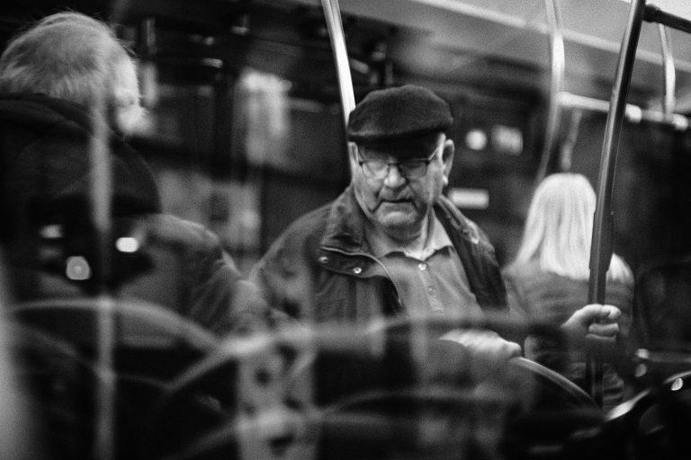 Passengers seated inside a bus in a black-and-white public-transit scene