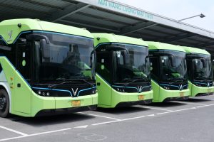 A row of green VinFast electric buses at a depot in Vietnam